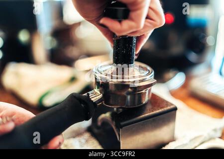 Barista streichelt den Portafilter Stockfoto