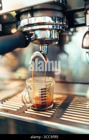 Doppelter Espresso in Messglas eingießen Stockfoto