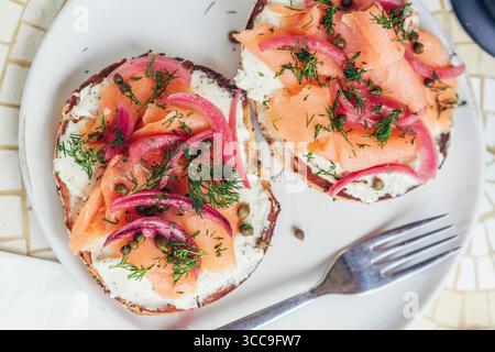 LOX Bagel mit eingelegten Zwiebeln und Kapern – Kopf mit Gabel Stockfoto