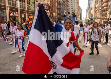 New York, Usa. August 2025. Teilnehmer mit Flagge der Dominikanischen Republik marschieren an der Dominican Day Parade auf der 6th Avenue am 10. August 2025 in New York City. Die National Dominican Day Parade feierte 43 Jahre Marsch auf der Sixth Avenue in Manhattan. Die Parade feiert dominikanische Kultur, Folklore und Traditionen. Quelle: SOPA Images Limited/Alamy Live News Stockfoto