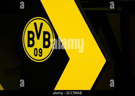 Nahaufnahme des Borussia Dortmund BVB 09-Logos auf auffälligem gelbem und schwarzem Hintergrund mit einem großen Pfeil, der die Kultfigur des Vereins unterstreicht Stockfoto