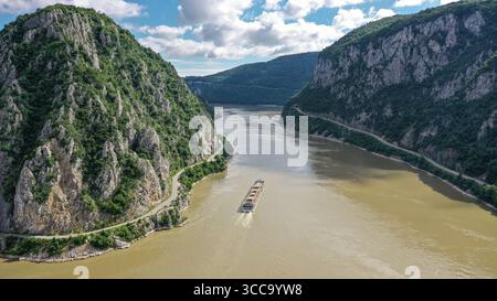 Drohnenblick aus der Luft, Flusskreuzfahrtschiff in die Kazan-Schlucht, kleine Kessel Mali Kazan), Berge des Djerdap-Nationalparks, rumänische serbische Grenze, Donau Stockfoto