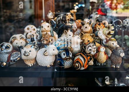 Farbenfrohe Tierfiguren aus Keramik sind hinter Glas in einem Schaufensterfenster ausgestellt. Sammlermarkt, Nostalgie-Design, Gedächtnismarketing Stockfoto