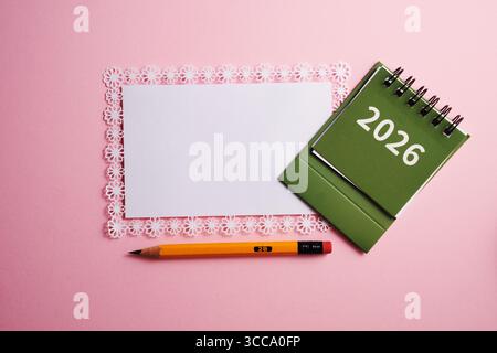 Schreibtischkalender 2026 und leerer Notizblock mit Bleistift Stockfoto
