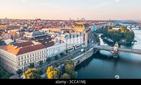 Smetana's Embankment bietet einen atemberaubenden Blick auf die Moldau und die Prager Stadtlandschaft. Das Licht am frühen Abend strahlt ein warmes Licht auf historische Gebäude entlang des Flusses aus. Stockfoto