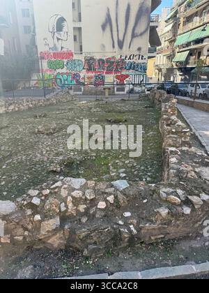 Urbane Straßenszene in Athen, Griechenland, mit antiken Ruinen umgeben von Graffiti-Kunst. Stockfoto