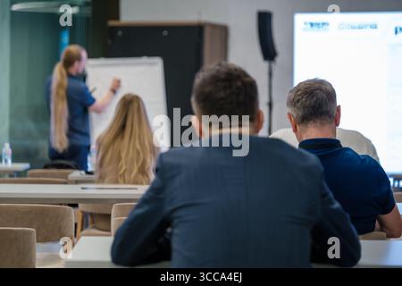 Gruppe von Personen, die an der Präsentation in Seminarumgebung mit Schwerpunkt auf Bildung und Lernen teilnehmen. Stockfoto