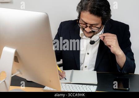 Junger männlicher Büroangestellter, der an einer Videokonferenz teilnimmt. Stockfoto