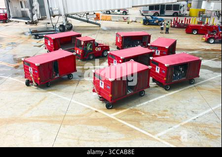 Rote Gepäckcontainer auf dem Asphalt eines Flughafens. Stockfoto