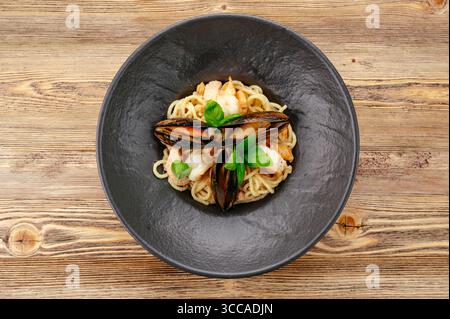 Pasta mit Meeresfrüchten auf einem schwarzen Teller Stockfoto