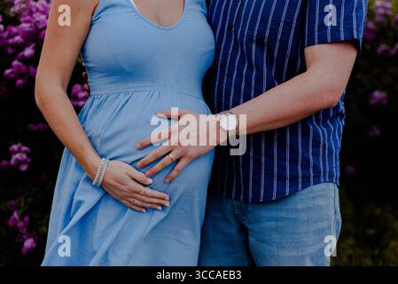 Ehemann hält das Baby seiner Frau im Park Stockfoto