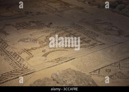 Sieben Kerzenstäbe Menora, ein Schofar- oder Widderhorn, andere jüdische Symbole und ein jüdisches Tierkreiszeichen auf einem Mosaikboden in einer ruinierten Synagoge aus dem 5. Jahrhundert. Stockfoto