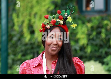 Frau mit Erdbeermütze bei den Wimbledon Champio nships 2025 in London, England, Großbritannien. Stockfoto