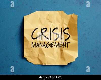 Gelbe zerknitterte Haftnotiz mit Worten für das Krisenmanagement auf blau strukturiertem Hintergrund repräsentiert die Bedeutung von Vorsorge Stockfoto