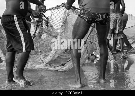 Ein halber Körper von nicht identifizierten Fischern, die ein Fischernetz ziehen. Angelsport. Brasilien Stockfoto