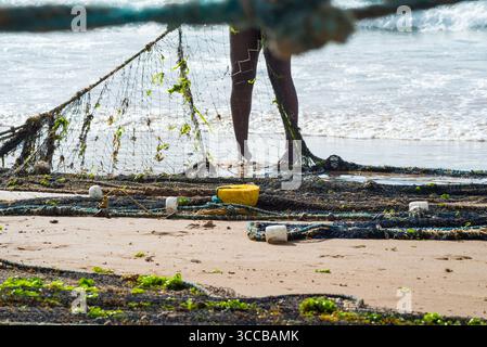 Der halbe Körper eines nicht identifizierten Fischers, der ein Fischernetz zieht. Fisch und Meeresfrüchte, Hobby. Brasilien Stockfoto