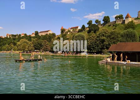 Die alte Herzogsstadt Burghausen ist die einwohnerstärkste Stadt im oberbayerischen Landkreis Altötting. Die Gemeinde liegt an der Salzach, die hier die Grenze zu Österreich bildet. Auf einem Höhenzug über der Altstadt erstreckt sich die Burg zu Burghausen, die mit 1051 Meter Länge die längste Burganlage der Welt ist. Im späten Mittelalter war Burghausen eine wichtige Nebenresidenz der bayerischen Herrscher. Burghausen gehört zur Tourismusregion Inn Salzach. Foto: Der Wöhrsee bzw das Wöhrseebad ist ein Badesee mit Ausblick zur Burg *** die alte herzogliche Stadt Burghausen ist die bevölkerungsreichste Stadt Stockfoto
