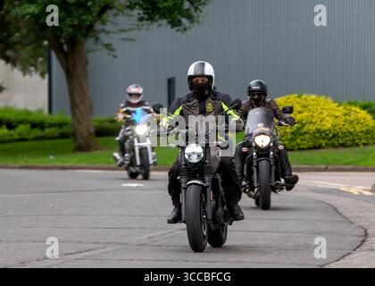Milton Keynes, Bucks, UK - 3. August 2025: Gruppe von drei Motorrädern, die auf einer britischen Straße unterwegs sind Stockfoto