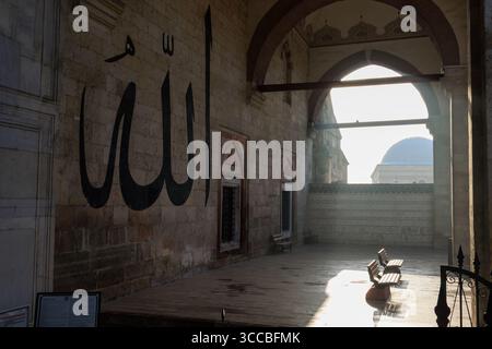 Zwei Bänke vor der arabischen Kalligraphie an der Wand der Ulu-Moschee in Edirne Stockfoto