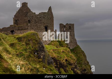 Dunluce Castle in Bushmills, Nordirland, das als Castle Pyke in Game of Thrones Staffel 1 dargestellt wurde, thronte dramatisch auf einer Klippe. Stockfoto