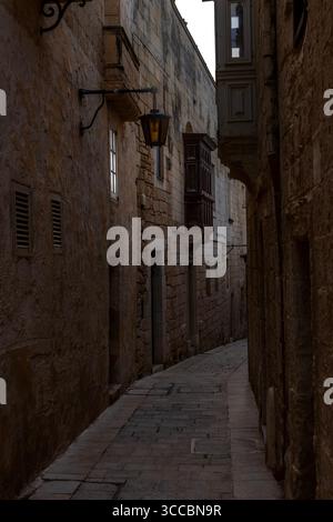 Eine ruhige Seitenstraße in Mdina, Malta, auch bekannt als Città Vecchia oder Città Notabile, bietet historische Architektur und mittelalterlichen Charme. Stockfoto