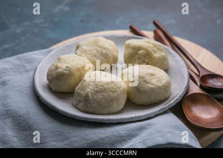 Traditionelles ukrainisches Gericht – faule Knödel aus weichem Hüttenkäse mit saftigen Kirschen im Inneren. Hausgemachte Küche, lecker und einfach zuzubereiten Stockfoto