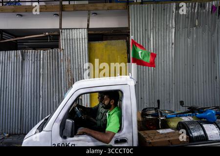 4. Dezember 2023, Bangkok, MalÃ, Malediven: Arbeiter fliegen eine maledivische Flagge auf ihrem Lkw, während sie an einer Baustelle in MalÃ vorbeifahren. Das tägliche Leben in MalÃ, Malediven, der Hauptstadt des Inselstaates im Indischen Ozean, deren Wirtschaft stark vom Tourismus abhängt. Die Bevölkerung des Landes umfasst viele ausländische Staatsangehörige, die aus Nationen weltweit arbeiten, darunter die Philippinen, Myanmar, Sri Lanka und Indien. die Bevölkerung ist überwiegend muslimisch. (Kreditbild: © Matt Hunt/ZUMA Press Wire) Stockfoto