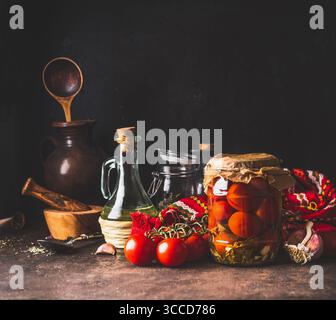 Home Dosen eingelegte Tomaten in Glas Glas auf rustikalen Tisch mit Zutaten. Hausgemachte der Ernte bei der Lagerung. Kopieren Sie Platz. Gesundes Essen. Stockfoto