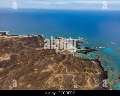 Atemberaubende Luftperspektive auf das vulkanische Gelände der Insel lobos, das mit dem lebhaften türkisfarbenen atlantik verschmilzt Stockfoto