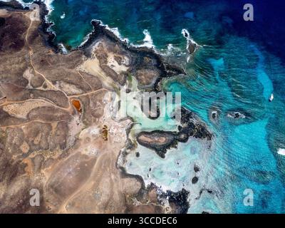 Atemberaubende Aussicht auf eine vulkanische Küste, die auf fuerteventura, den kanarischen Inseln, das türkisfarbene Wasser des atlantiks trifft Stockfoto