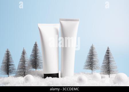 Schönheitskonzept für die Winterpflege mit Kosmetikprodukten und Weihnachtsdekorationen auf blauem Hintergrund, Vorderansicht, Kopierraum Stockfoto