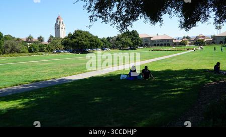 Blick auf den Campus der Stanford University mit Hoover Tower und Main Quad, Studenten, die sich auf dem Rasen entspannen, Palo Alto, Kalifornien, USA Stockfoto