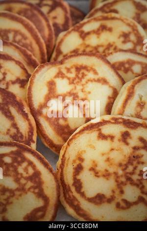Nahaufnahme von kleinen Pfannkuchen mit Textur und goldenen Kanten, präsentiert als Frühstücksessen. Stockfoto