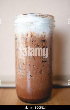 Frisch gebrühter Kaffee in einem zylindrischen Glas auf dem Tisch von oben senkrecht. Stockfoto