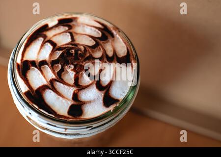 Frisch gebrühter Kaffee in einem zylindrischen Glas auf dem Tisch in der Nähe der Oberseite Stockfoto