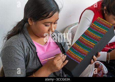 6. Dezember 2018, San Antonio Arrazola, Oaxaca, Mexiko: Handwerker malen Zapotec-Designs auf Boxen für Flaschen mit Mescal in einem Geschäft/einer Werkstatt in San Antonio Arrazola, Oaxaca, Mexiko. (Kreditbild: © Jon G. Fuller / Vwpics/VW Pics via ZUMA Press Wire) Stockfoto