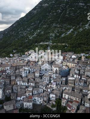 Blick aus der Vogelperspektive auf malerische Gebäude, eingebettet an den majestätischen Berg, mit einem Kirchturm, der in den Himmel ragt, Majella Nationalpark, Provinz L'Aquila, Italien. Stockfoto