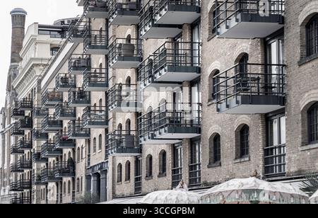 London, UK - 21. Juli 2025 - ein mehrstöckiges Gebäude, das sich durch seine Backsteinfassade, Bogenfenster und zahlreiche Balkone mit dunklem Geländer auszeichnet Stockfoto