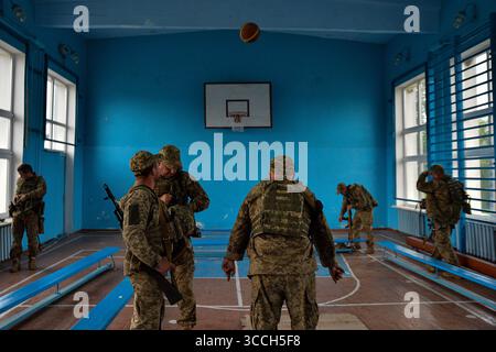 23. Mai 2023, Kiew, Oblast Doentsk, Ukraine: Nach dem Training spielen die Mitglieder der Kiewer Territorialverteidigung mit einem Basketballball in einer Donbass-Schule. Ein Basketball schwebt durch die Luft, nachdem er von einem ukrainischen Soldaten geworfen wurde, verpasste er den Schuss. (Bild: © Madeleine Kelly/ZUMA Press Wire) Stockfoto