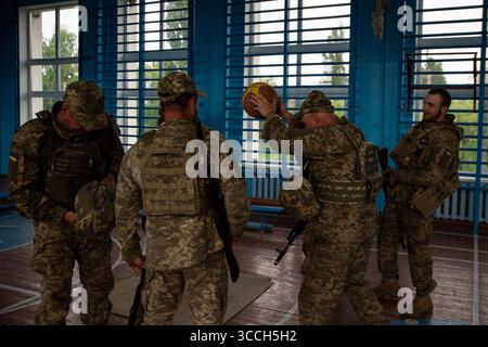23. Mai 2023, Kiew, Oblast Donezk, Ukraine: Nach Abschluss des Kampftrainings spielen ukrainische Soldaten Basketball in einer örtlichen Schule. Die Mitglieder der Kiewer Territorialverteidigung wurden kürzlich im Donbass stationiert und werden ihre Ausbildung für die Frontlinien fortsetzen (Bild: © Madeleine Kelly/ZUMA Press Wire) Stockfoto