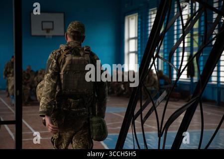 23. Mai 2023, Kiew, Oblast Donezk, Ukraine: Ein Soldat der Kiewer Territorialverteidigung geht durch die Tür, um nach dem Einsatz im Donbass mit dem Kampftraining zu beginnen. â œDad Battalionâ € die meisten in der Ausbildung sind mittleren Alters oder älter. (Bild: © Madeleine Kelly/ZUMA Press Wire) Stockfoto