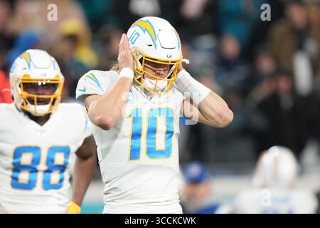 14. Januar 2023, Jacksonville, Florida, USA: Der Quarterback der Los Angeles Chargers Justin Herbert (10) hat Schwierigkeiten, den Pay Call zu hören, weil die Fans während des Wildcard-Playoff-Spiels zwischen den Los Angeles Chargers und den Jacksonville Jaguars am Samstag, 14. Januar 2023 im TIAA Bank Field in Jacksonville, Florida, Florida (Kreditbild: © Peter Joneleit/ZUMA Press Wire) Stockfoto