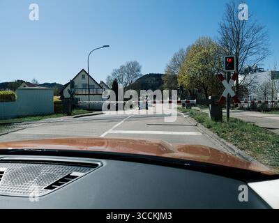 Baden, Deutschland - 6. April 2025: Innenansicht eines Wagens an einem geschlossenen ländlichen Bahnübergang in Baden-Württemberg, mit Barrieren gegen einen Freiraum Stockfoto