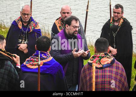 30. März 2023, Furnas, Azoren, Portugal: Ein römisch-katholischer Priester hält am Ufer des Furnassees eine Predigt an Pilger, genannt Romeiros, während ihrer 8-tägigen Wanderung um die Azoren-Insel Sao Miguel, am 30. März 2023 in Lagoa das FurnÃ, Portugal. Die Pilger besuchen 100 Schreine und Kirchen während der Veranstaltung aus dem Jahr 1522, als ein Erdbeben die ersten Siedlungen zerstörte. (Bild: © Richard Ellis/ZUMA Press Wire) Stockfoto