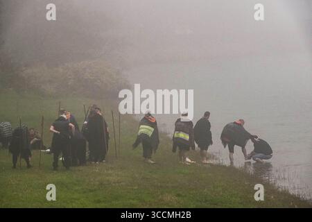 30. März 2023, Furnas, Azoren, Portugal: Ein römisch-katholischer Priester wäscht die Füße von Pilgern, die als Romeiros bekannt sind, in dichtem Nebel am Ufer des Furnassees, 30. März 2023 in Lagoa das FurnÃ, Portugal. Die Pilger besuchen 100 Schreine und Kirchen während ihrer 8-tägigen Wanderung um die Azoren-Insel Sao Miguel, die aus dem Jahr 1522 stammt, als ein Erdbeben die ersten Siedlungen zerstörte. (Bild: © Richard Ellis/ZUMA Press Wire) Stockfoto