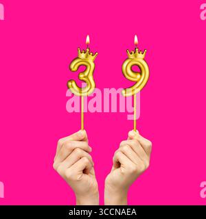 Geburtstag auf Fuchsiahintergrund mit der Zahl 39 - Hände mit Zahlenkerzen Stockfoto
