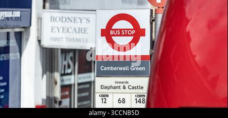 LONDON, Großbritannien - 5. AUGUST 2025 - Rot-weißes Londoner Bushaltestelle am Camberwell Green mit Busnummern und Richtung Elephant and Castle Stockfoto