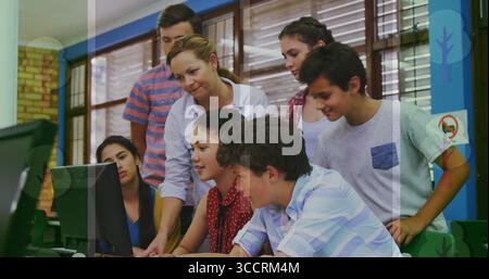 Lehrer in weißer Bluse, der Schüler mit Tastatur und Maus im Computerlabor der Schule führt Stockfoto