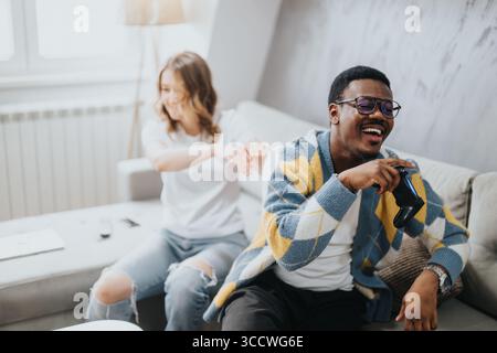 Ein vielseitiges Paar, das einen verspielten Moment zu Hause genießt Stockfoto