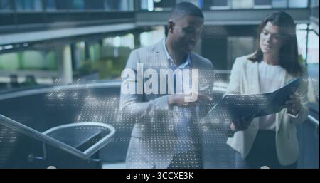 Studieren von Kollegen in Anzügen, die Dateien im Vorhof zeigen und scannen, mit schwarzem Ordner Stockfoto